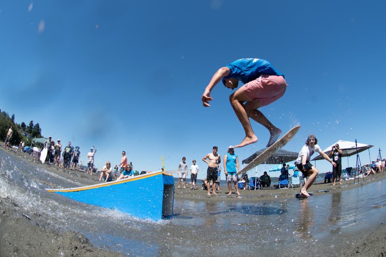 Beachfest skimboarder above the Dash Point beach course